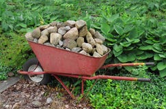 wheelbarrow-rocks-old-red-overflowing-load-43077384.jpg